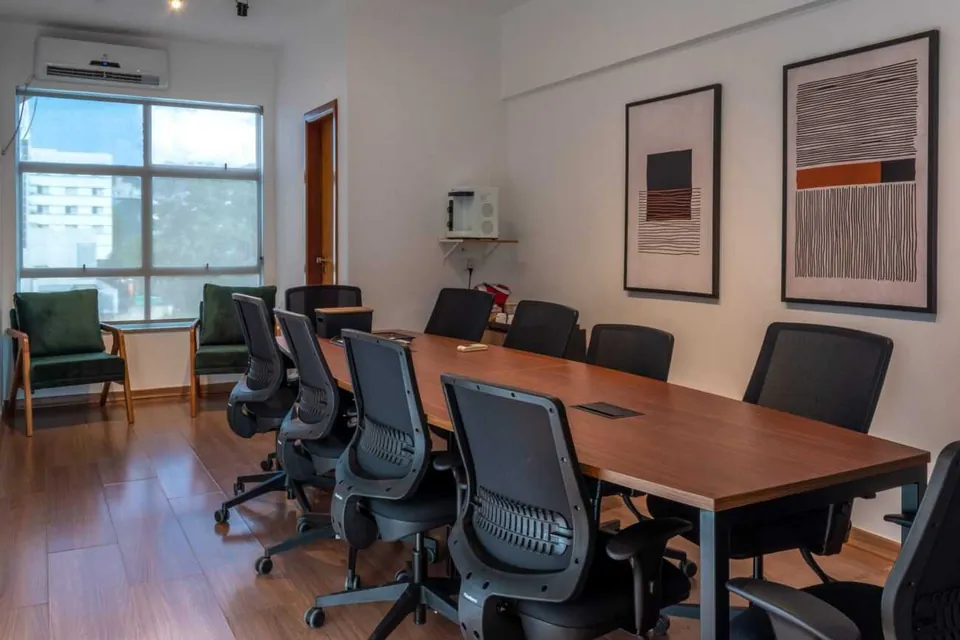 Sala de reunião fechada, com mesa central e cadeiras, no Desk Coworking em Belo Horizonte.